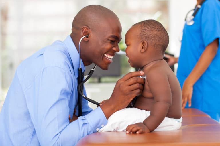 Male black doctor examining baby