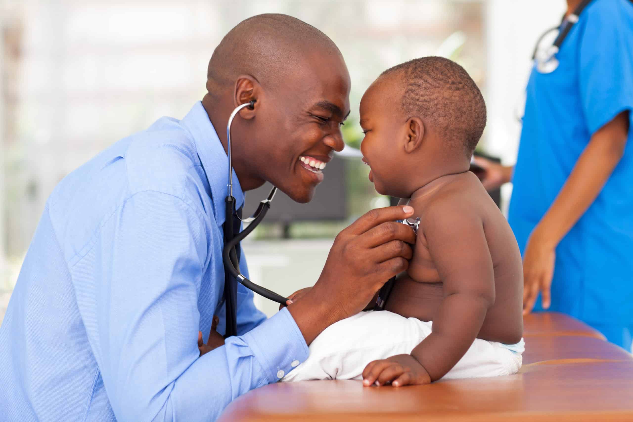 Male black doctor examining baby