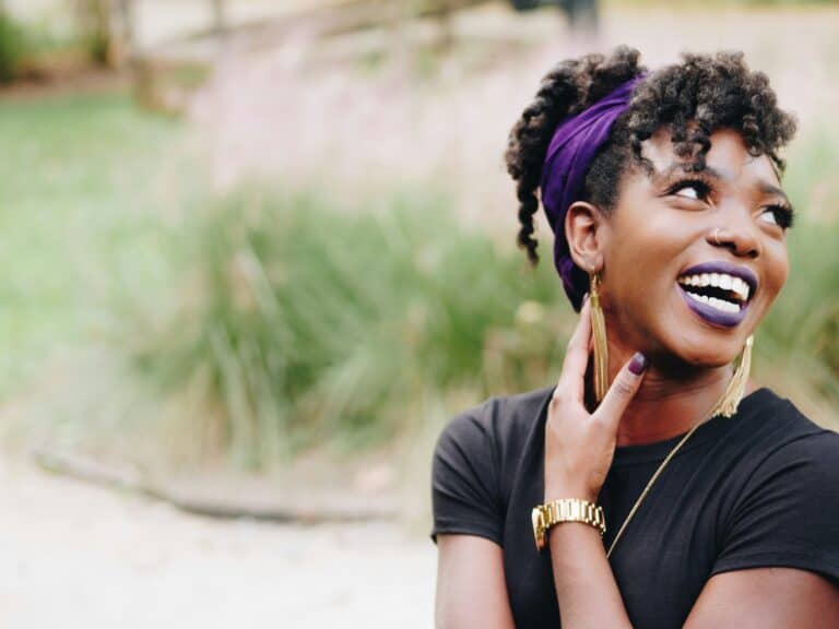 smiling black woman touching neck
