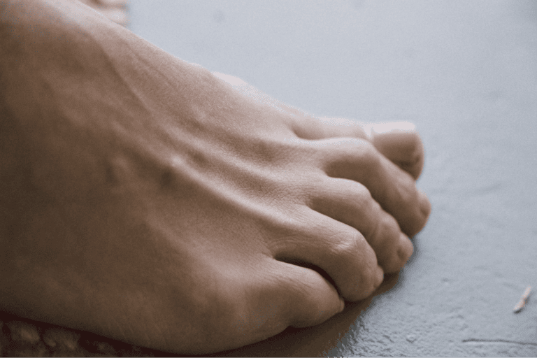Close-up of toenails on gray floor