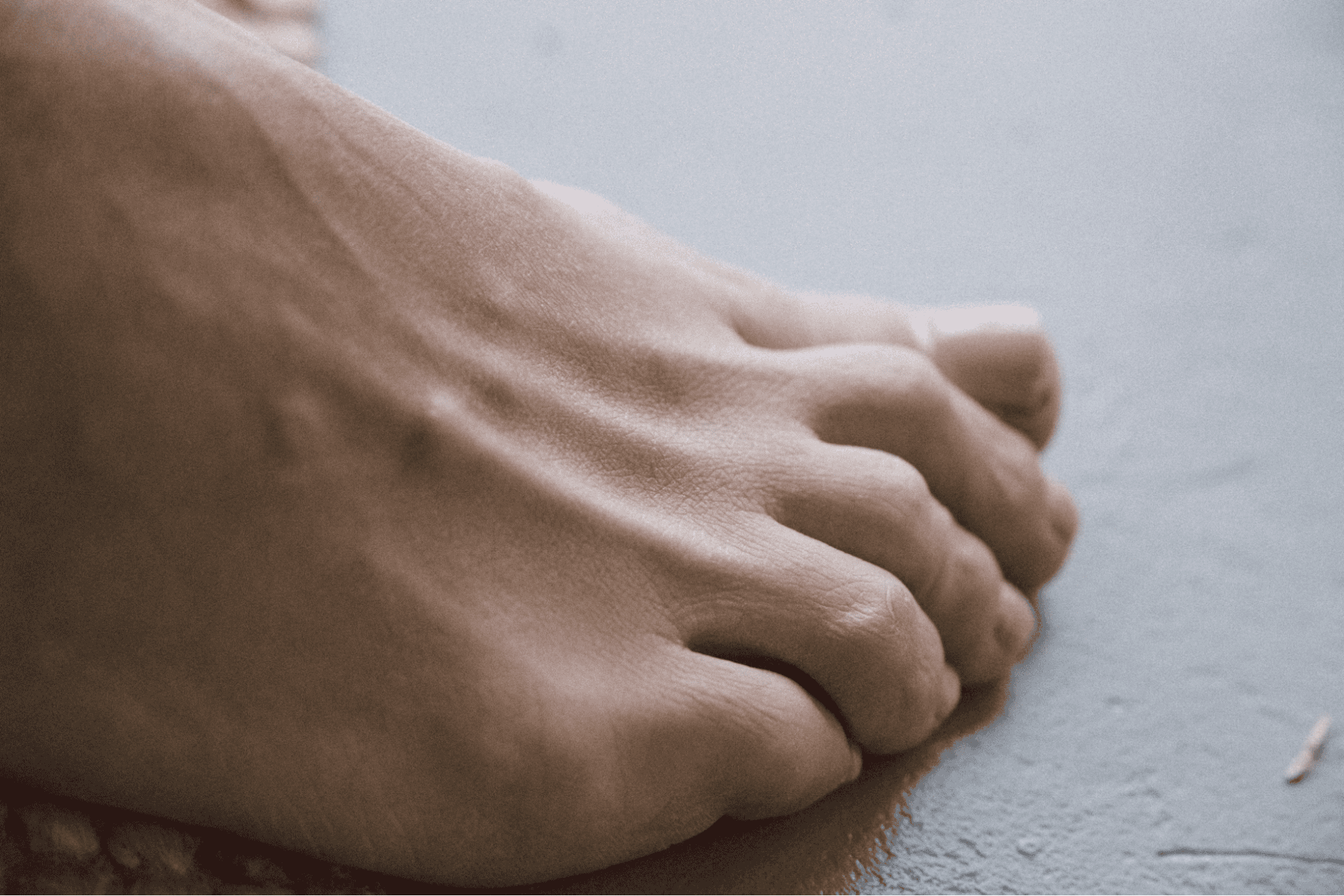 Close-up of toenails on gray floor