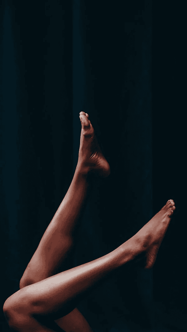Bent legs against black background