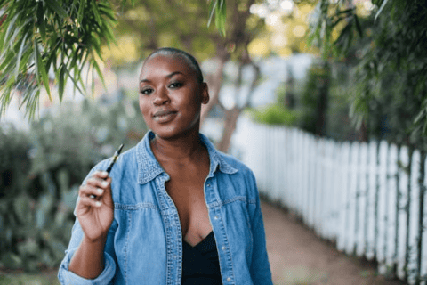 Female with short hair in front of white picket fence