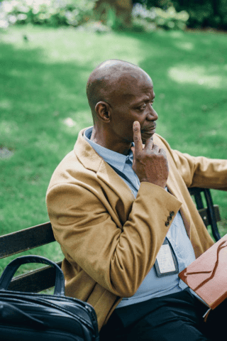 Bald male seated on park bench