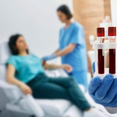 Woman lying on the bed while having blood test