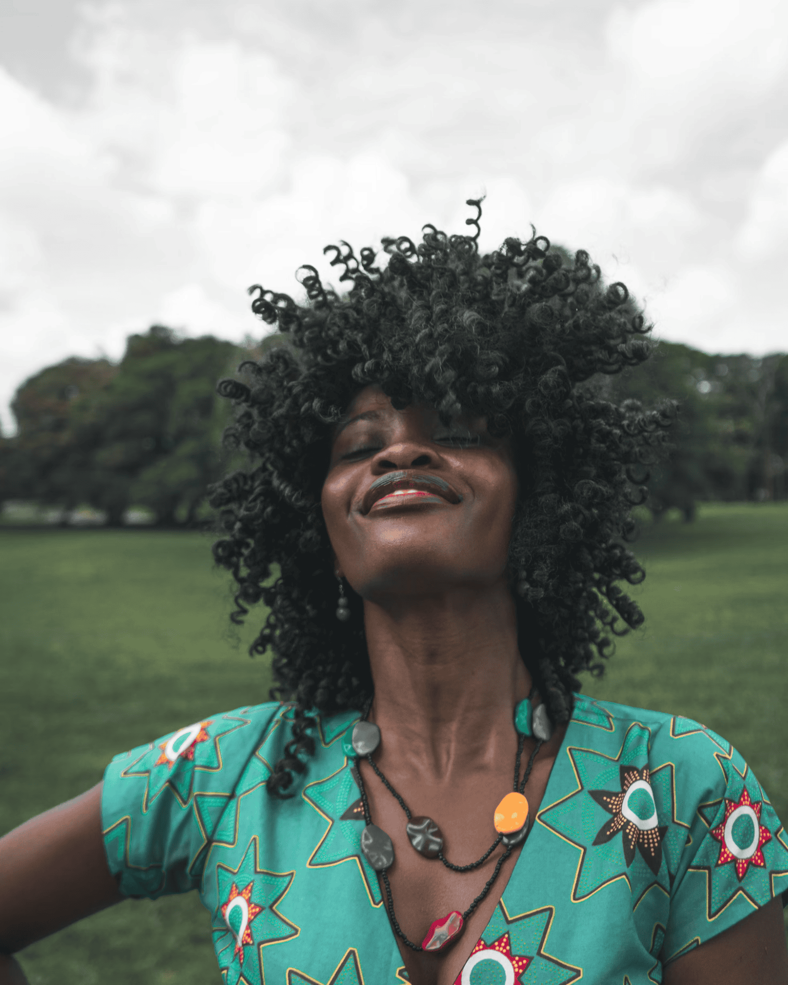 Individual with curly hair outdoors