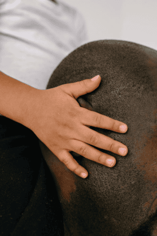 Child’s hand on individual’s scalp