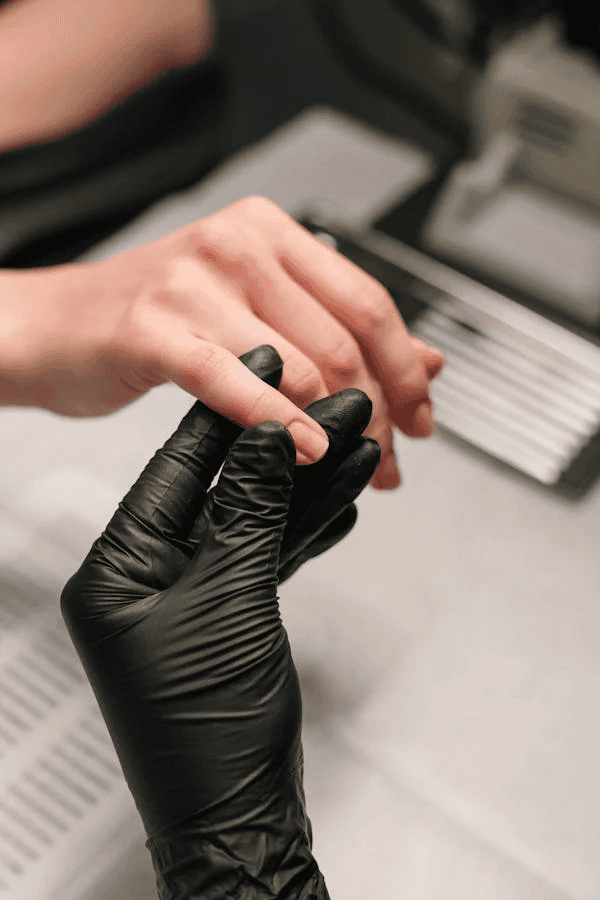 Black gloved hand holding pinky